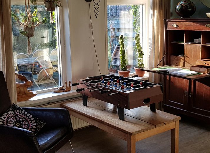 Gemuetliches Wohnzimmer von De Sjouw in Hoorn, Terschelling, mit geraeumiger Sitzecke und gemuetlichem Holzofen fuer einen entspannten Aufenthalt.