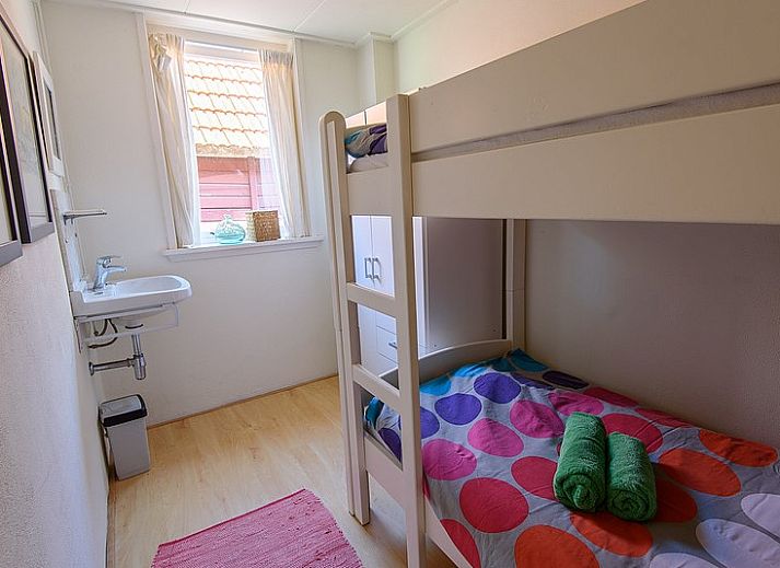 Gemuetlicher Innenraum in De Sjouw, Hoorn, Terschelling, mit bequemen Sofas und einem rustikalen Kamin fuer gemuetliche Abende.