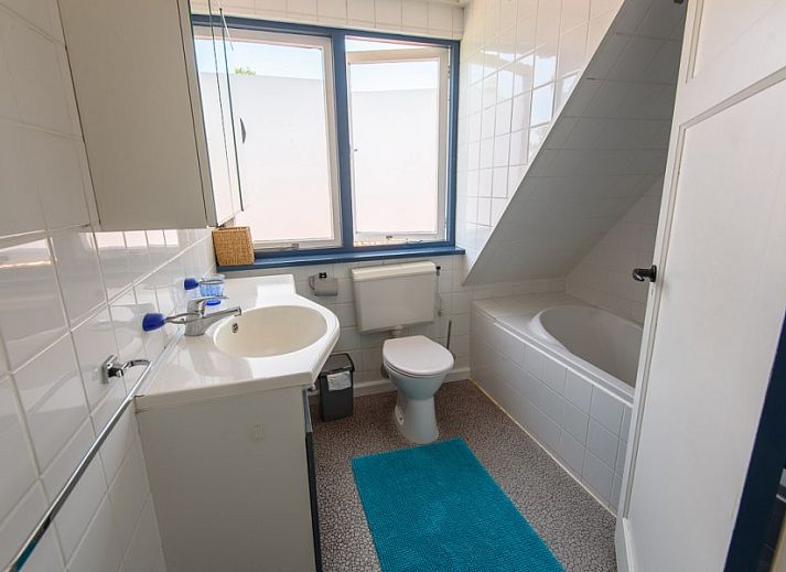 Gemuetlicher Innenraum in De Sjouw, Hoorn, Terschelling, mit bequemen Sofas und einem rustikalen Kamin fuer gemuetliche Abende.