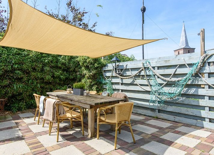 Gemuetlicher Innenraum in De Sjouw, Hoorn, Terschelling, mit bequemen Sofas und einem rustikalen Kamin fuer gemuetliche Abende.