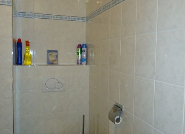 Lichte woonkamer in Aike van Rel appartement, Hoorn, Terschelling met moderne inrichting en kleurrijke kunst.