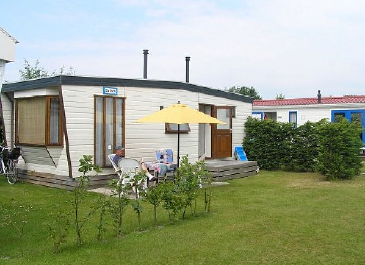 Chalet De Stern in Hoorn, Terschelling, met zonnig terras en groene omgeving, ideaal voor ontspanning op de Waddeneilanden.
