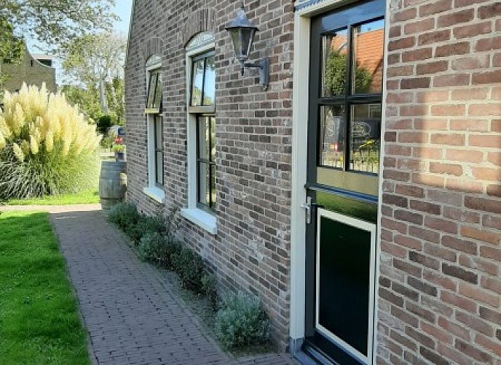 Charmant vakantiehuis Noordhoorn in Hoorn, Terschelling met bloementuin en traditionele architectuur.