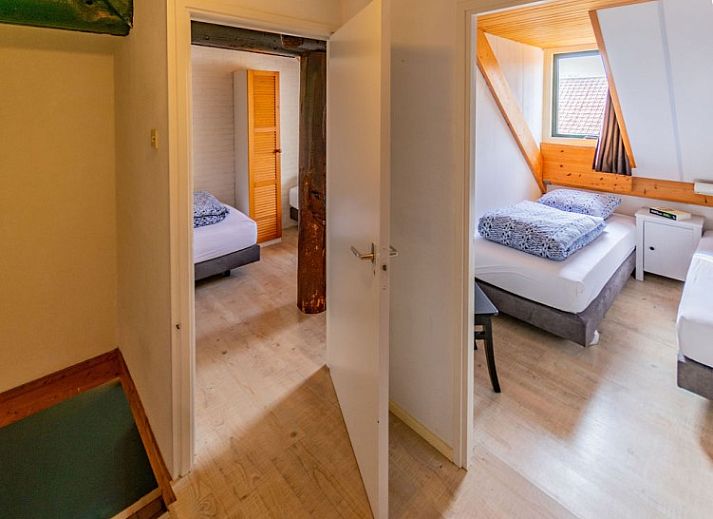 Cozy living room in Haas 2 apartment, Hoorn, Terschelling with wooden beams and comfortable seating area.