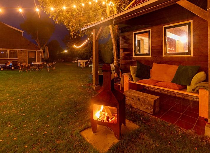 Cozy living room in Haas 2 apartment, Hoorn, Terschelling with wooden beams and comfortable seating area.