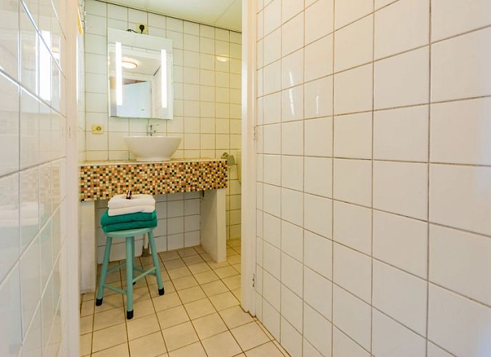 Dining area and kitchen in Haas 2 vacation home, Hoorn, Terschelling with modern furnishings and wooden accents.