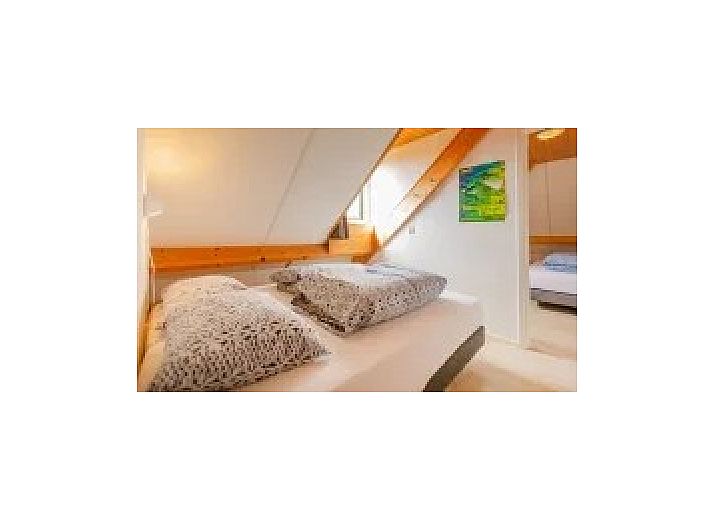 Atmospheric terrace at Kip 2 in Hoorn, Terschelling with evening lighting and a cozy outdoor fireplace.