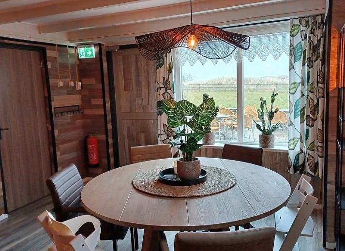 Buitenterras van Duinvilla De Reddingboot in Oosterend, Terschelling met speeltoestellen en zitgelegenheid.