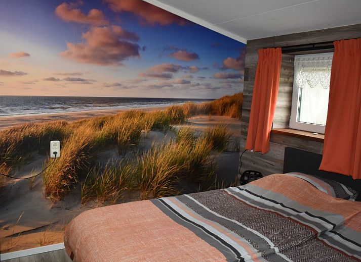 Buitenterras van Duinvilla De Reddingboot in Oosterend, Terschelling met speeltoestellen en zitgelegenheid.