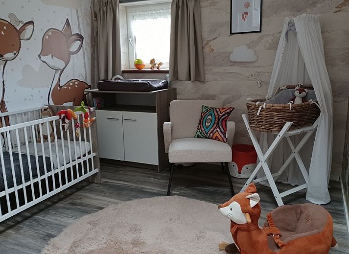 Buitenterras van Duinvilla De Reddingboot in Oosterend, Terschelling met speeltoestellen en zitgelegenheid.