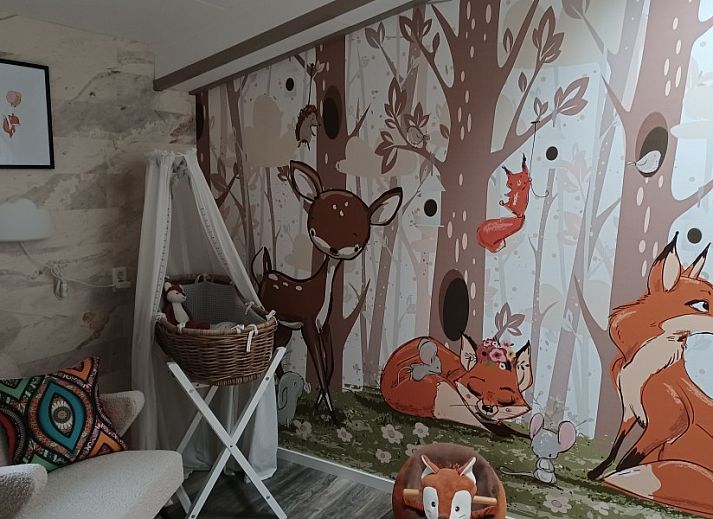 Buitenterras van Duinvilla De Reddingboot in Oosterend, Terschelling met speeltoestellen en zitgelegenheid.