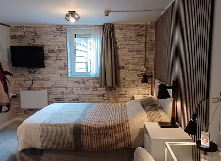 Stylish bedroom with floral wallpaper in cottage in Oosterend, Wadden Islands.