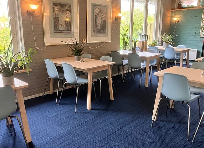 Stylish bedroom with floral wallpaper in cottage in Oosterend, Wadden Islands.