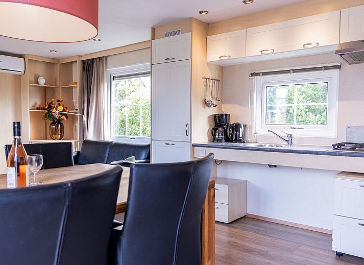 Gezellige eetkamer in Duinbungalow Mindervalide, Oosterend, Terschelling met moderne voorzieningen en natuurlijk licht.