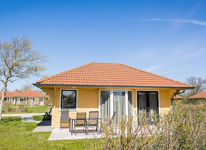 Villabungalow vakantiehuis in Oosterend, Terschelling met zonnig terras en rode dakpannen, omgeven door natuur op de Waddeneilanden.