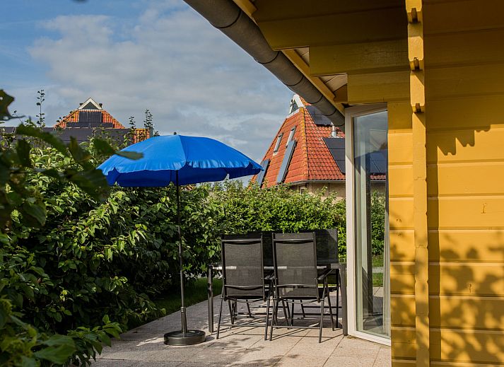 Villabungalow vakantiehuis in Oosterend, Terschelling met zonnig terras en rode dakpannen, omgeven door natuur op de Waddeneilanden.