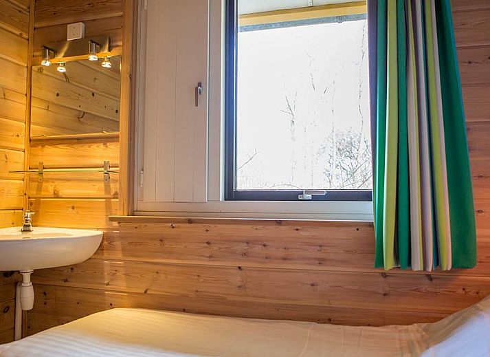 Villabungalow vakantiehuis in Oosterend, Terschelling met zonnig terras en rode dakpannen, omgeven door natuur op de Waddeneilanden.