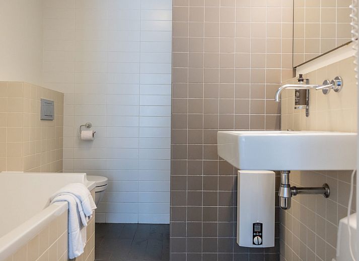 Apartment Bad Douche in Oosterend, Terschelling offers a sunny terrace with comfortable lounge chairs and an inviting garden setting.