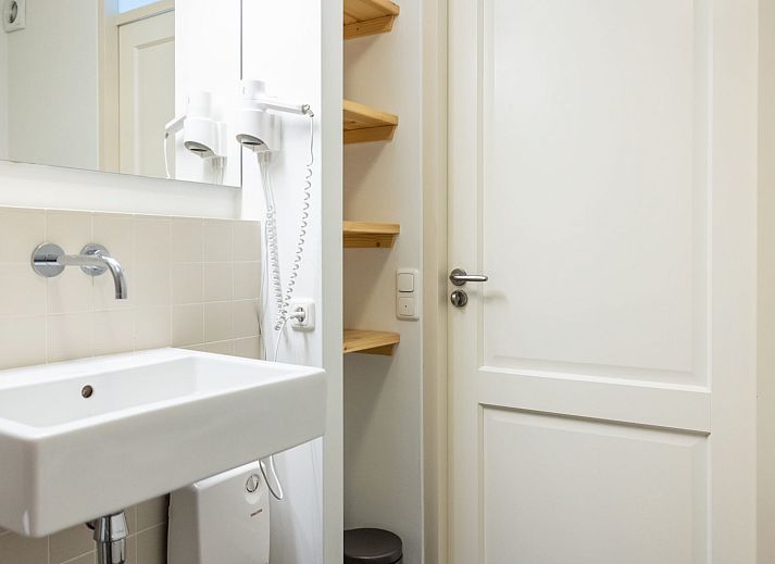 Apartment Bad Douche in Oosterend, Terschelling offers a sunny terrace with comfortable lounge chairs and an inviting garden setting.