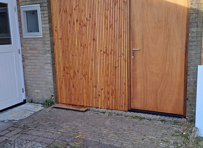 Beleuchtete Abendansicht des Ferienhauses in Midsland Noord, Terschelling, mit einladender Terrasse und gruener Umgebung auf den Watteninseln.