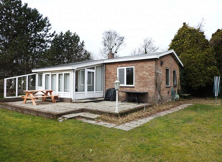 Vakantiehuis Botter in Midsland Noord op Terschelling met groene tuin en vlag.