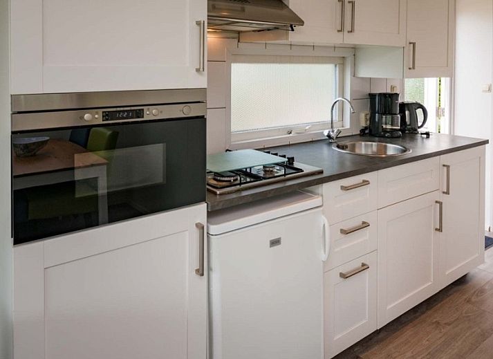 Buitenzijde van Unesco vakantiehuis met uitzicht op groene velden in Midsland Noord, Terschelling.