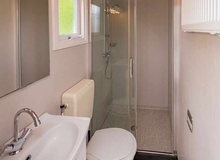 Buitenzijde van Unesco vakantiehuis met uitzicht op groene velden in Midsland Noord, Terschelling.