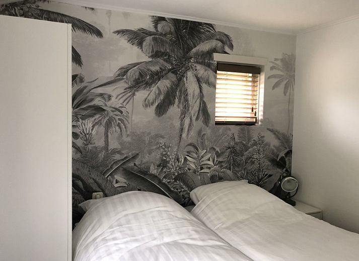 Zijaanzicht van Vakantiehuis Bikkel in Midsland Noord, omringd door weelderig groen.