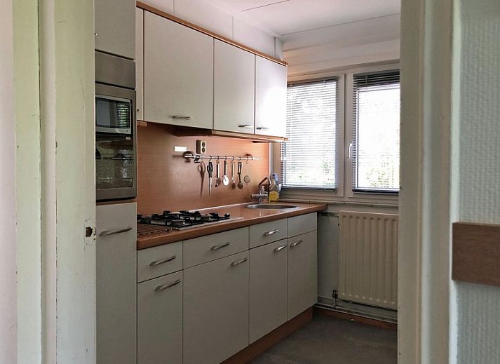 Zijaanzicht van Vakantiehuis Bikkel in Midsland Noord, omringd door weelderig groen.