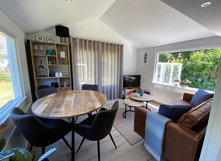 Sfeervolle woonkamer van Vakantiehuis Bengel in Midsland Noord, Terschelling, met uitzicht op de groene natuur van de Waddeneilanden.