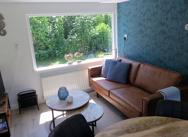 Sfeervolle woonkamer van Vakantiehuis Bengel in Midsland Noord, Terschelling, met uitzicht op de groene natuur van de Waddeneilanden.