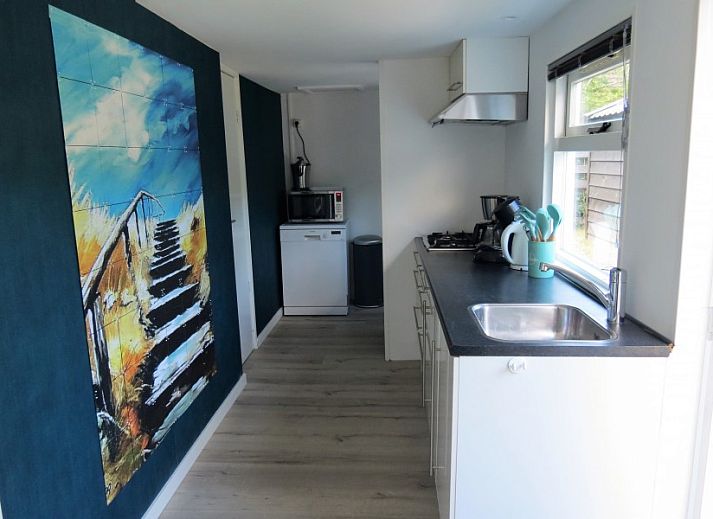 Sfeervolle woonkamer van Vakantiehuis Bengel in Midsland Noord, Terschelling, met uitzicht op de groene natuur van de Waddeneilanden.