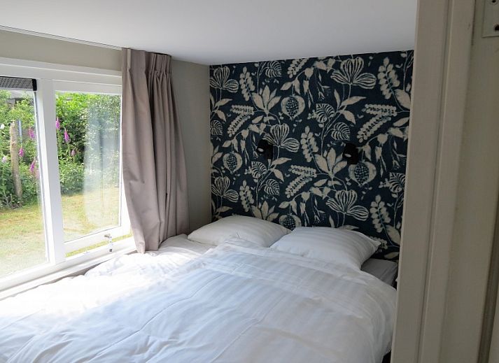 Sfeervolle woonkamer van Vakantiehuis Bengel in Midsland Noord, Terschelling, met uitzicht op de groene natuur van de Waddeneilanden.