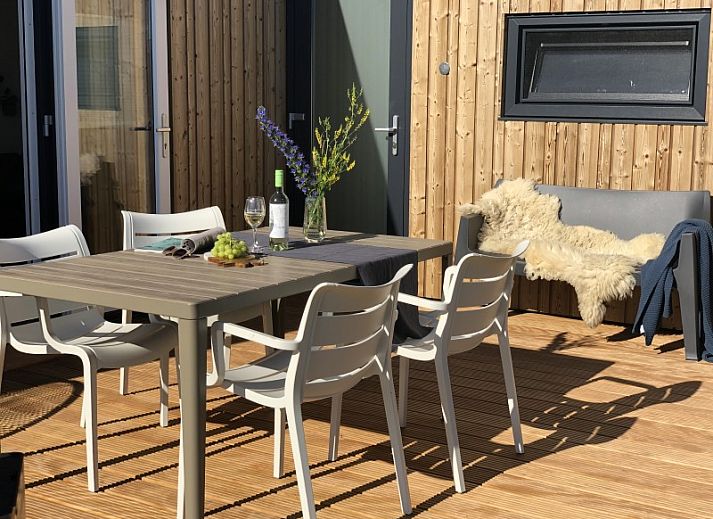 Veranda van Buitenhuis chalet in Midsland Noord, Terschelling met zitplek en bloemen.