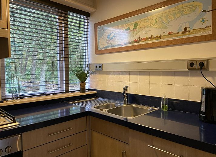 Gemuetlicher Innenbereich des Ferienhauses Belhamel in Midsland Noord, Terschelling mit bequemen Sitzgelegenheiten und grossen Fenstern.