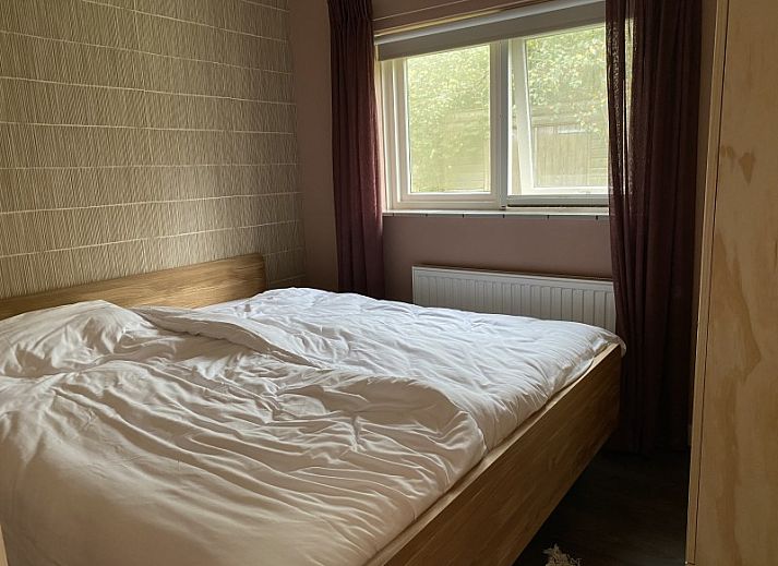 Gemuetlicher Innenbereich des Ferienhauses Belhamel in Midsland Noord, Terschelling mit bequemen Sitzgelegenheiten und grossen Fenstern.