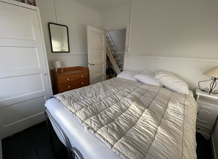 Terrasse des Duinhuis in Midsland Noord, Terschelling, mit bequemen Sitzgelegenheiten und Blick auf den gruenen Garten fuer einen entspannten Urlaub.