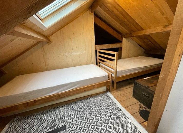 Terrasse des Duinhuis in Midsland Noord, Terschelling, mit bequemen Sitzgelegenheiten und Blick auf den gruenen Garten fuer einen entspannten Urlaub.