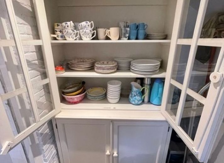 Terrasse des Duinhuis in Midsland Noord, Terschelling, mit bequemen Sitzgelegenheiten und Blick auf den gruenen Garten fuer einen entspannten Urlaub.