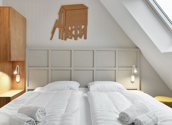 Lichte woonkamer van 4-persoons penthouse 4CP in West-Terschelling, met comfortabele zithoek en uitzicht op de duinen.