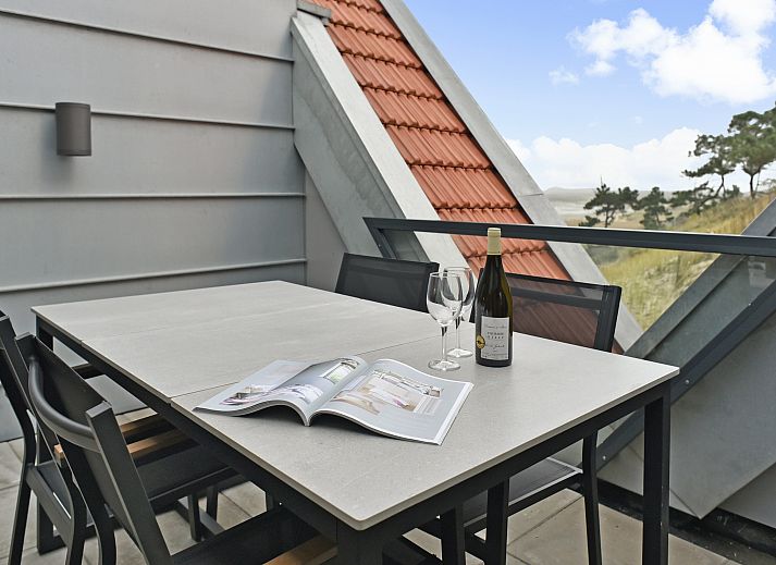 Lichte woonkamer van 4-persoons penthouse 4CP in West-Terschelling, met comfortabele zithoek en uitzicht op de duinen.