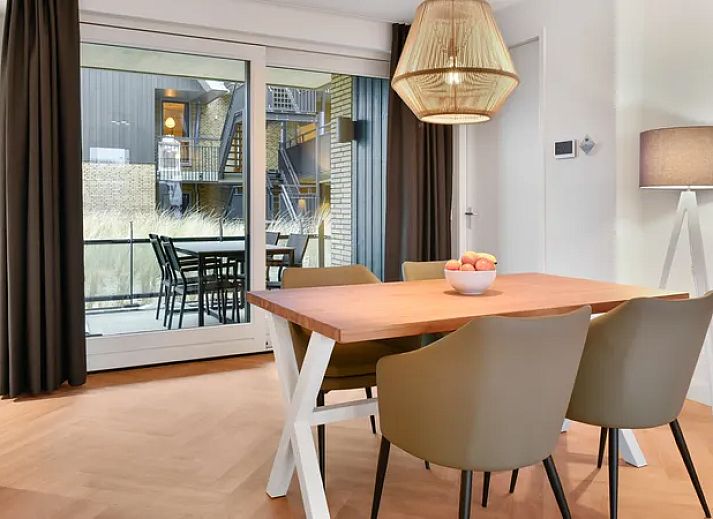 Eetkamer van 4-persoons appartement 4C1 in West-Terschelling met uitzicht op balkon, Waddeneilanden.