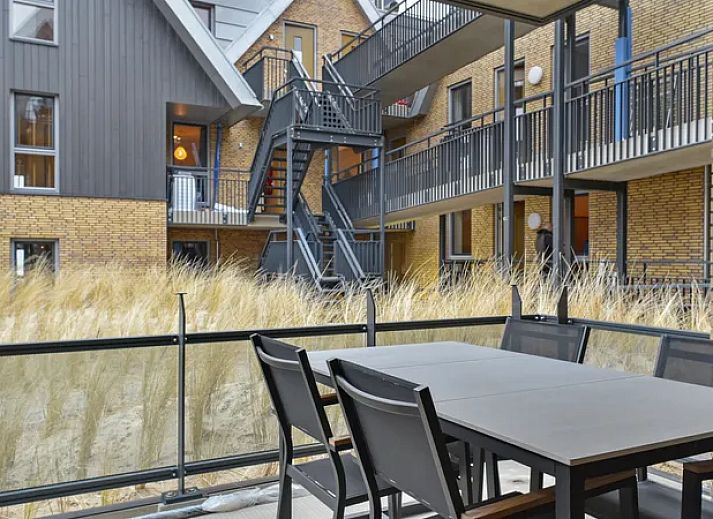 Eetkamer van 4-persoons appartement 4C1 in West-Terschelling met uitzicht op balkon, Waddeneilanden.
