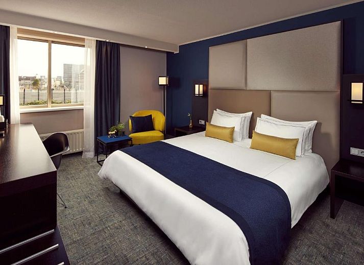 Comfortabele slaapkamer in Park Plaza Utrecht, vakantieappartement in Utrecht met grote ramen en prachtig uitzicht.