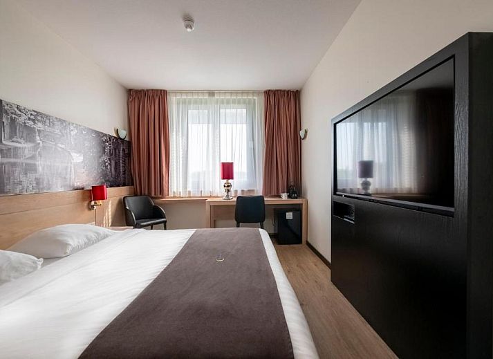Comfortabele slaapkamer in Bastion Hotel Utrecht met uitzicht op Utrecht, ideaal voor een ontspannen verblijf.