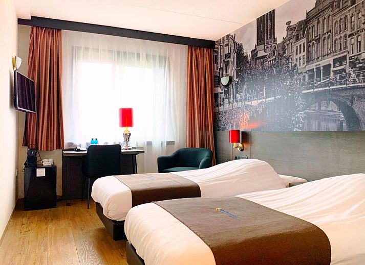 Comfortabele slaapkamer in Bastion Hotel Utrecht met uitzicht op Utrecht, ideaal voor een ontspannen verblijf.