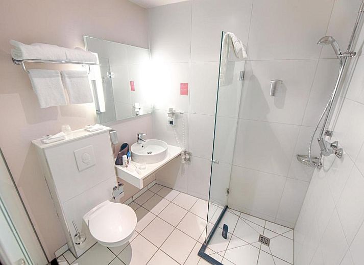 Luxe slaapkamer in Apollo Hotel Utrecht City Centre met balkon en uitzicht op Utrecht, ideaal voor een ontspannen verblijf.