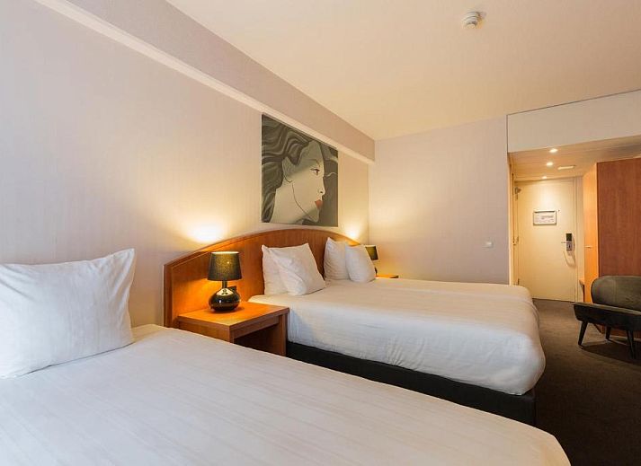 Luxe slaapkamer in Apollo Hotel Utrecht City Centre met balkon en uitzicht op Utrecht, ideaal voor een ontspannen verblijf.