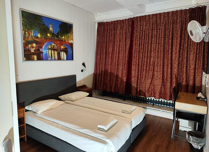 Moderne slaapkamer in Hotel Holland Lodge, Utrecht met comfortabel bed en houten accenten.