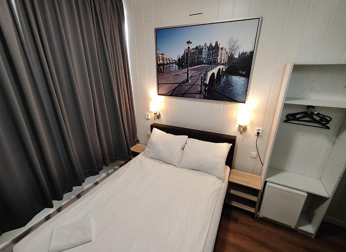 Ruime kamer in Hotel Holland Lodge Utrecht met grote ramen en sfeervolle verlichting.